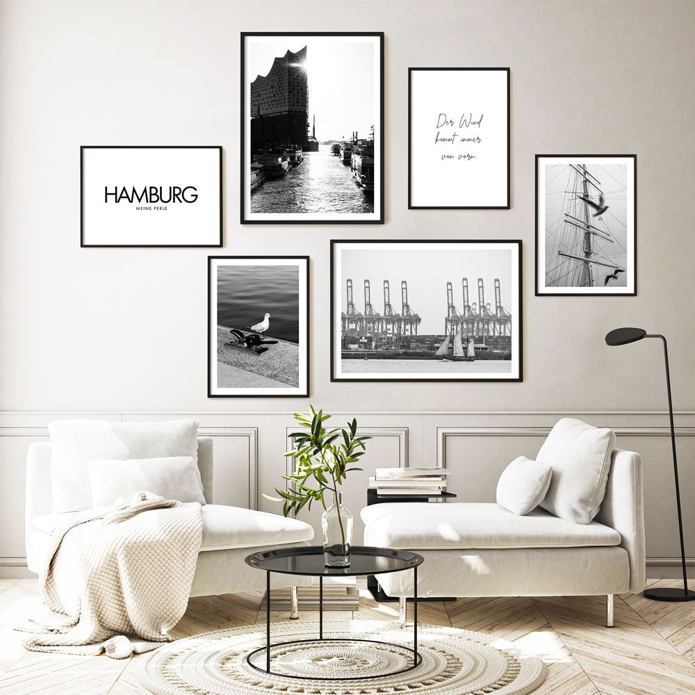 Schwarz Weiß Hamburg Poster in schwarzen Rahmen an der Wohnzimmerwand. 4 Hafen Fotografien kombiniert mit 2 Spruch Bildern.