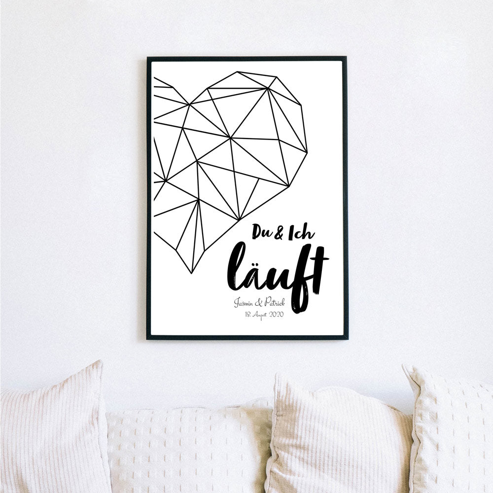 Du & Ich Läuft Poster mit großen schwarzen Herz. Unten personalisierbare Namen und Datum. Bild im schwarzen Bilderrahmen an der Wand.