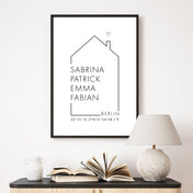 Personalisiertes Haus Familienposter mit individuellen Namen, Ort und Koordinaten. Gerahmt in einem schwarzen Bilderrahmen über der Kommode.
