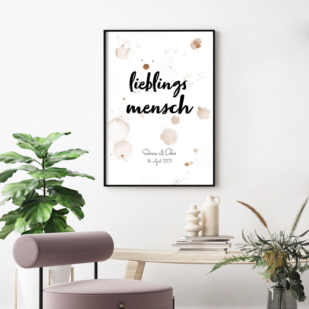 lieblingsmensch Poster mit farb-Spritzern im Hintergrund. Personalisierte Namen und Datum unten im Bild. Fertig gerahmt an der Wand.