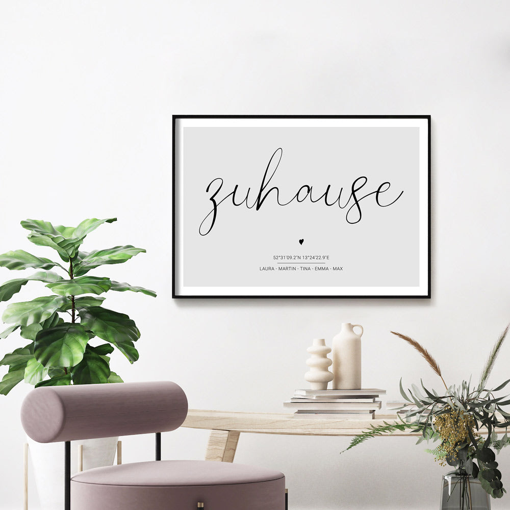 Personalisiertes Poster im schwarzen Rahmen an der Wand. Zuhause Schriftzug auf grauem Hintergrund. Individuelle Koordinaten und Vornamen darunter.