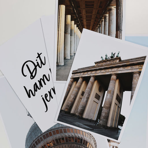 Nahaufnahme vom Brandenburger Tor Poster und darunter die restlichen Berlin Bilder vom Set.