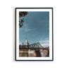 Frankfurt Poster vom Eisernen Steg und der Skyline im Hintergrund. Bild mit weißen umlaufenden Rand. Gerahmt in einem schwarzen Bilderrahmen.