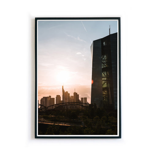 Frankfurt Poster der EZB zum Sonnenuntergang. Im Hintergrund die Frankfurt Skyline. Bild im schwarzen Bilderrahmen