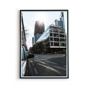 Frankfurt Poster von den Straßen Frankfurts im Street Style. Sonnenstrahlen hinter der Frankfurter Skyline. Bild im schwarzen Bilderrahmen.