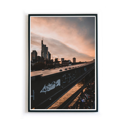 Frankfurt Poster vom Eisernen Steg zum Sonnenuntergang. Frankfurter Skyline im Hintergrund. Bild im schwarzen Rahmen.