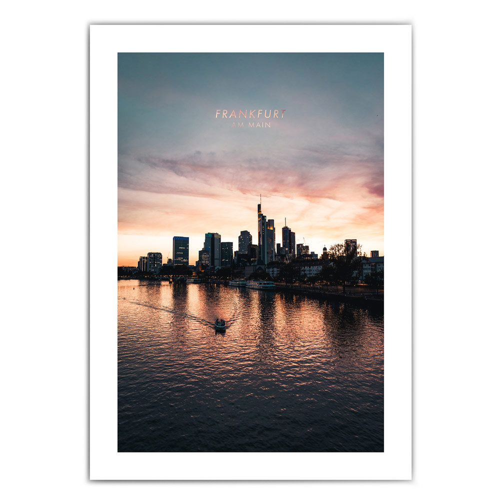 Frankfurt am Main Skyline Poster. Farbenfroher Sonnenuntergang, kleines Boot fährt im Vordergrund über den Main. Bild mit 5cm umlaufenden weißen Rand.