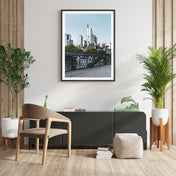 Frankfurt am Main Skyline Poster im Retro Look. Bild mit weißen umlaufenden Rand. Bild im schwarzen Bilderrahmen an der Wand.