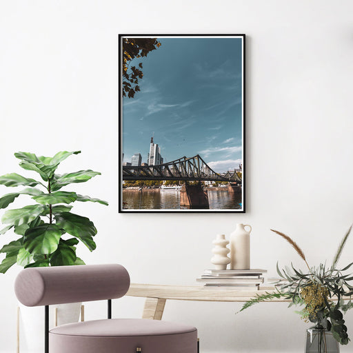 Frankfurt Poster vom Eisernen Steg und der Skyline im Hintergrund. Bild im Rahmen an der Wand über einen Tisch im Wohnzimmer.