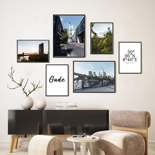 Frankfurt Poster Set mit 6 Postern. Fotografien der Frankfurter Skyline und Hochhäuser mit 2 Spruchbildern. Bilderwand in schwarzen Rahmen im Wohnzimmer an der Wand.
