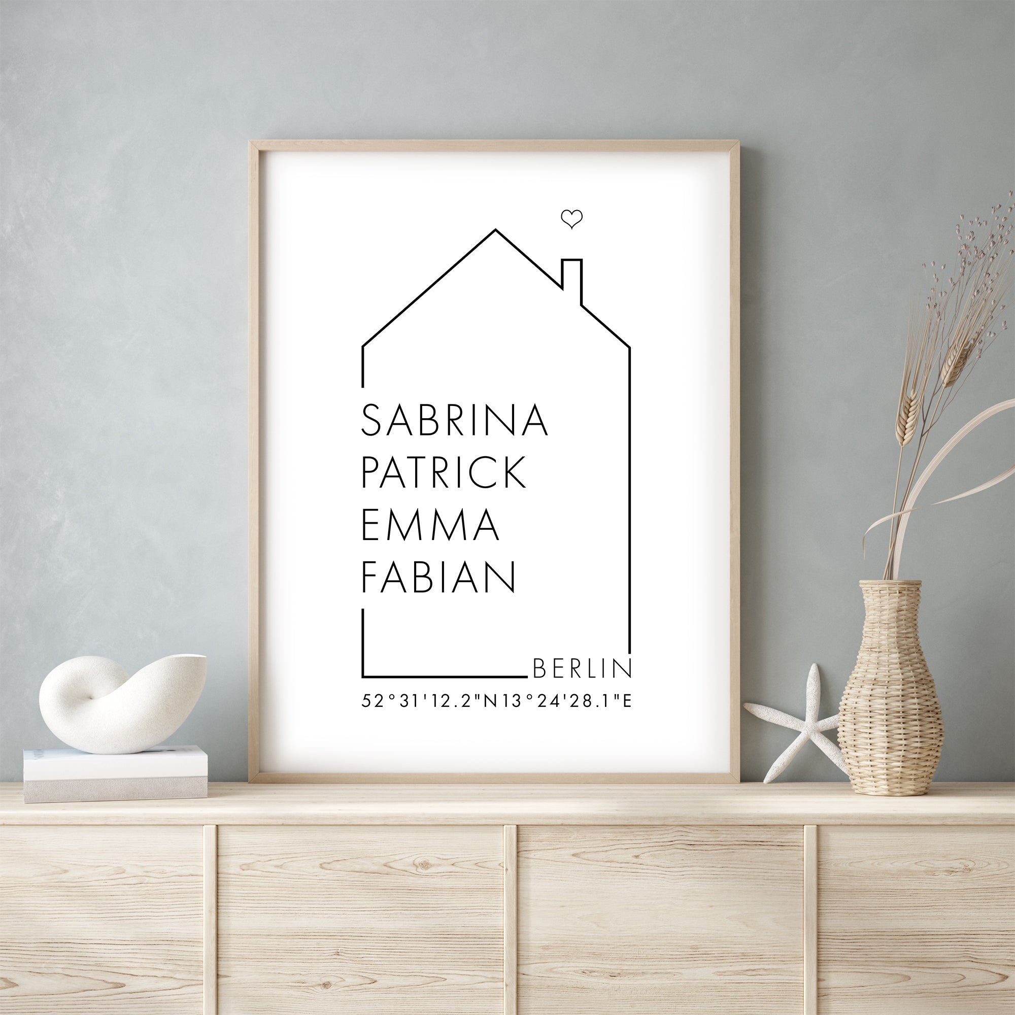 Familienposter mit einem Haus indem personalisierte Namen, Ort und Koordinaten stehen. Ideal als Geschenk zum Einzug.