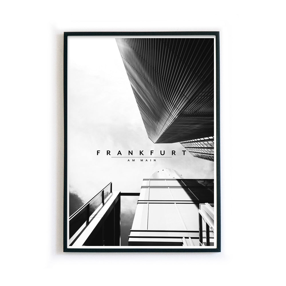Schwarz Weiß Frankfurt Poster, blick nach oben von der Straße in die Hochhäuser. Frankfurt Schriftzug in der Mitte. Bild im schwarzen Bilderrahmen.