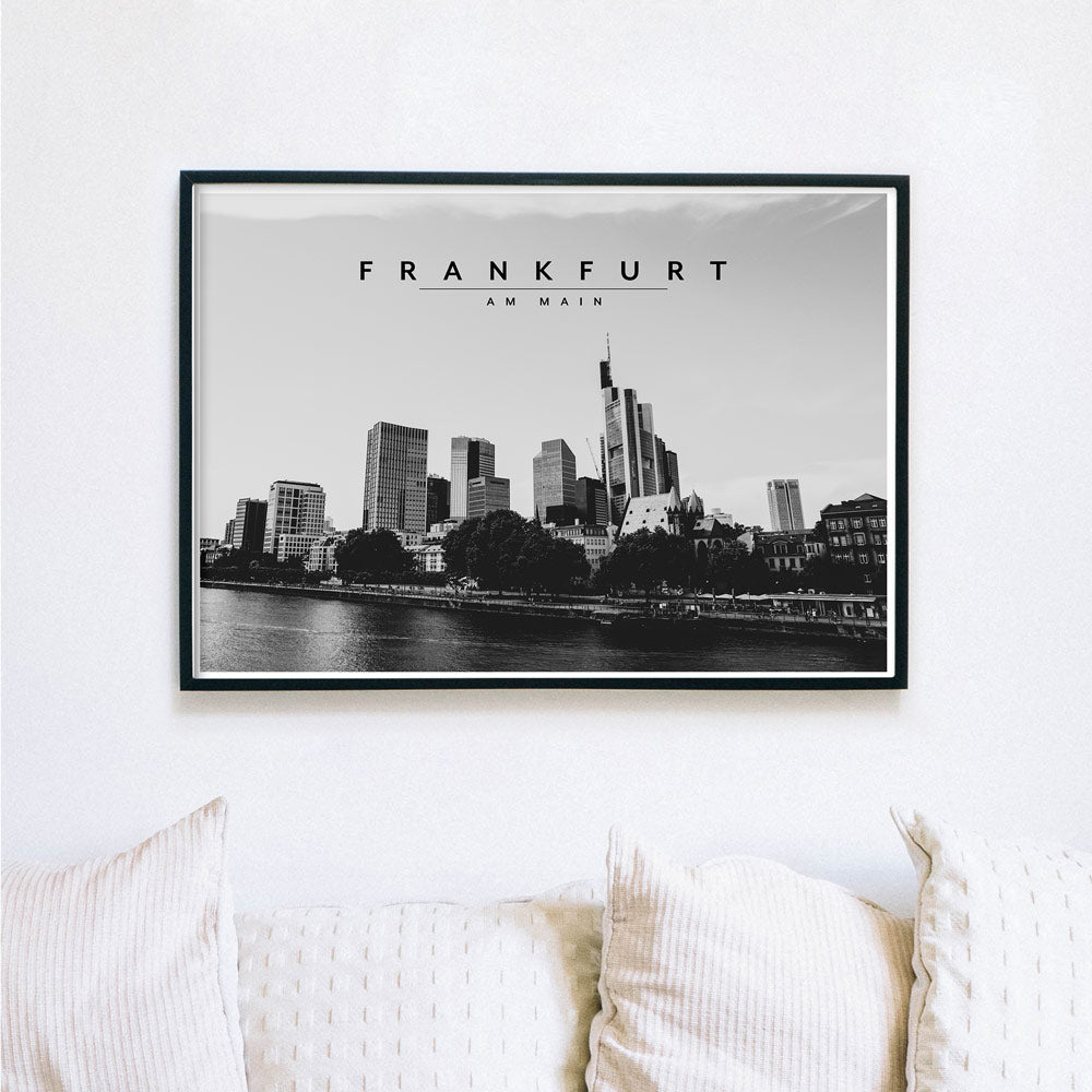 Schwarz Weiß Frankfurt Poster im Querformat. Skyline von Frankfurt am Main. Bild im schwarzen Bilderrahmen an der Wand über eine Sofa.