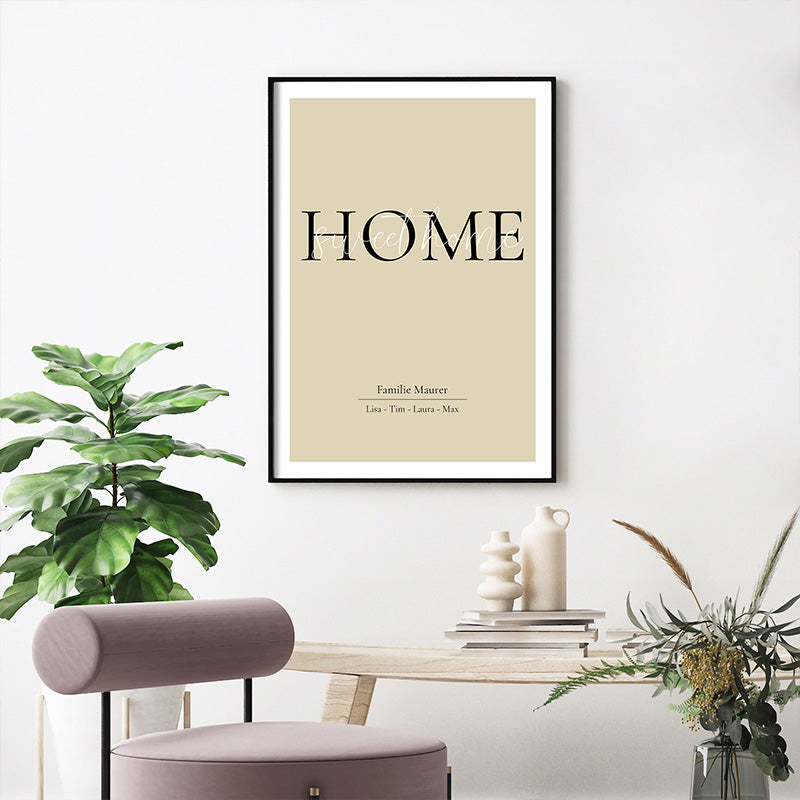 Personalisiertes Poster Home Sweet Home mit dem Familiennamen und Vornamen auf einen beigen Hintergrund. Wandbild im schwarzen Rahmen vor einem Tisch