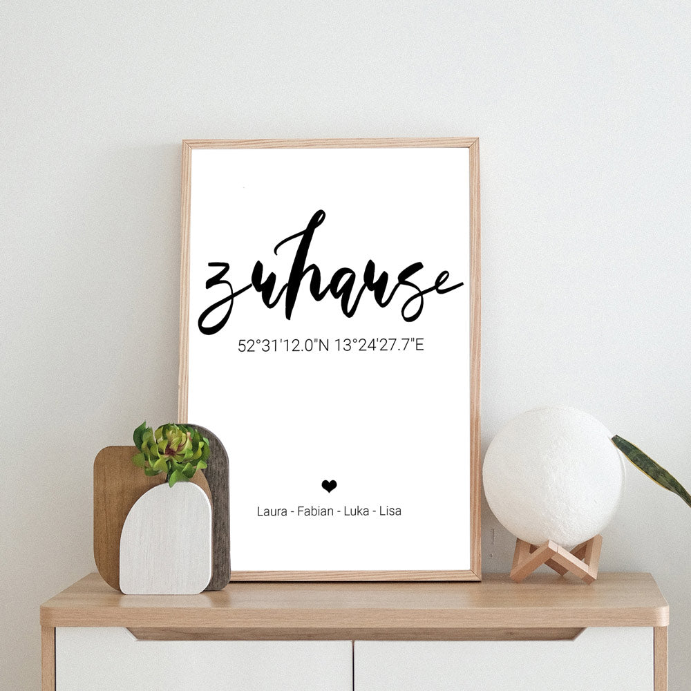 Zuhause Poster mit personalisierten Koordinaten und Namen. Im beigen Holzrahmen abgestellt auf einer Kommode.