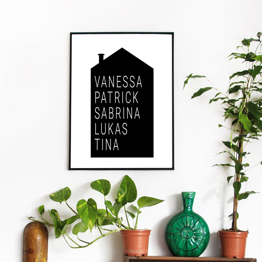 Schwarzen Haus mit personalisierbaren Vornamen in weißer Schrift. Poster im schwarzen Bilderrahmen an der Wand mit Pflanzen.