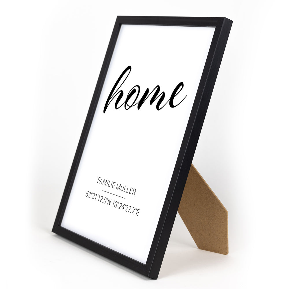 Personalisiertes home Poster mit Familiennamen und Koordinaten. Bild im schwarzen Din A4 Bilderrahmen mit Aufsteller.