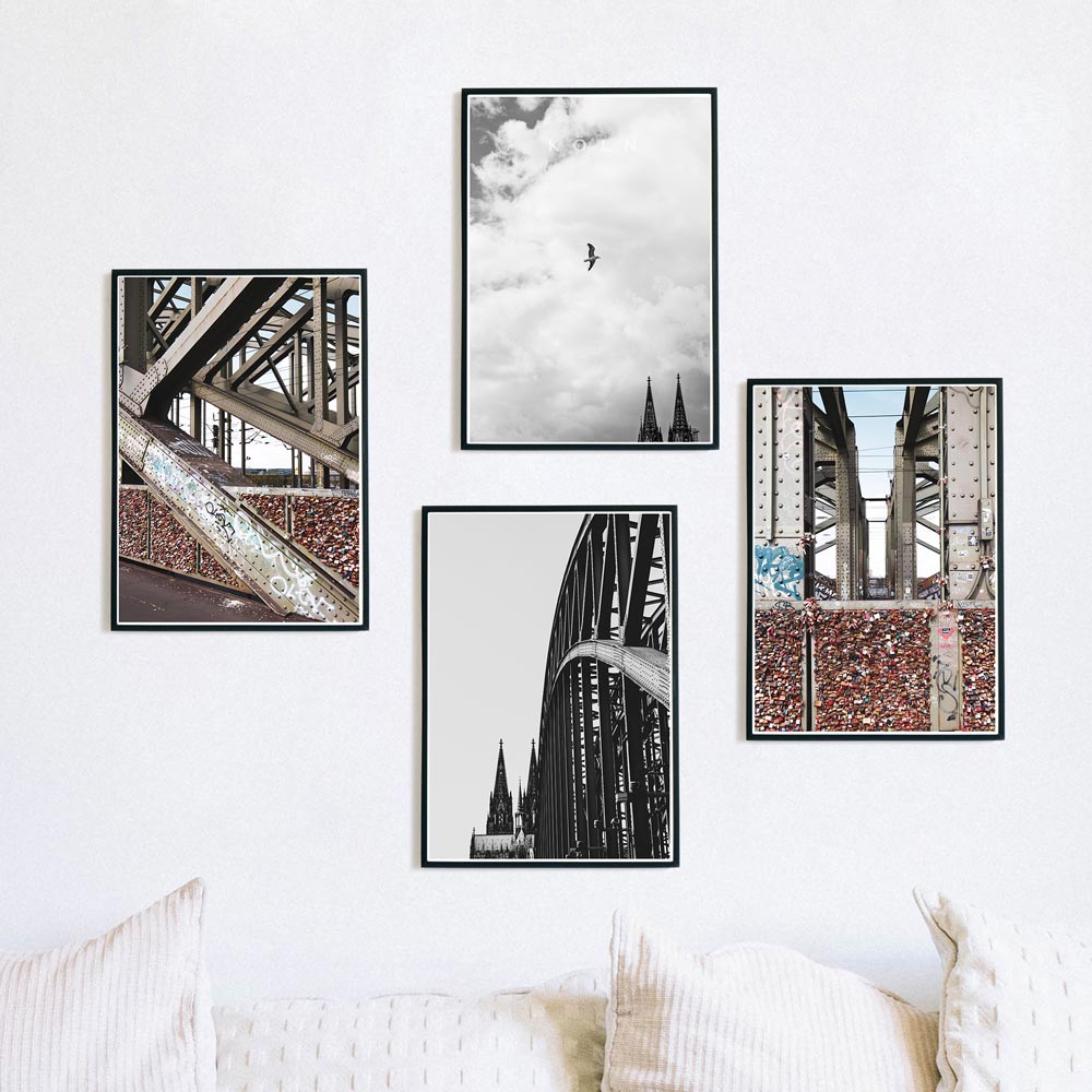 4er Köln Poster Set mit zwei schwarz weiß Bildern vom Kölner Dom und zwei Bilder der Hohenzollernbrücke in Farbe. Poster in Rahmen über dem Sofa.