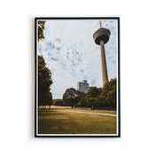 Retro Köln Poster vom Fernsehturm im grünen Gürtel. Grüne Wiese und Bäume im Vordergrund bei blauem bewölkten Himmel. Bild im Rahmen.
