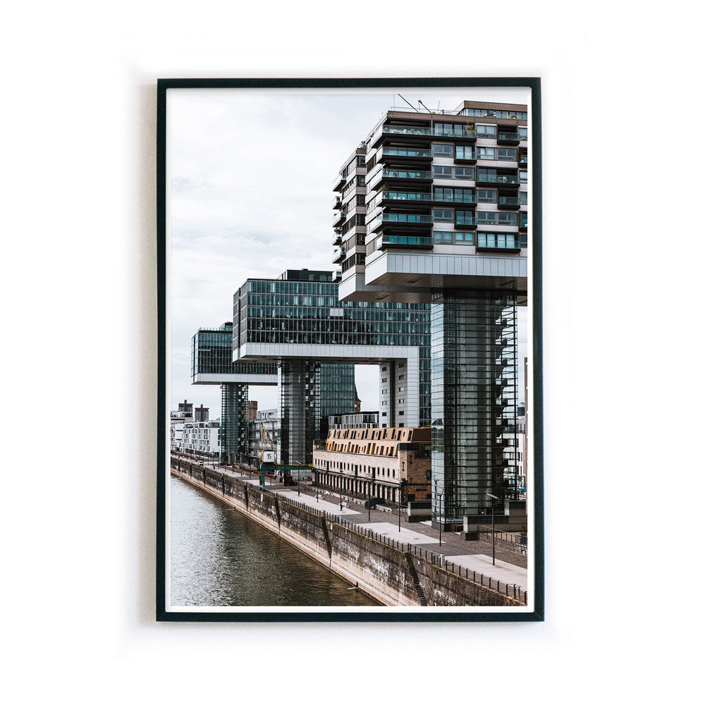 Wandbild der Kranhäuser am Rheinauhaufen in Köln. Poster ist im Hochformat und in einem schwarzen Bilderrahmen.