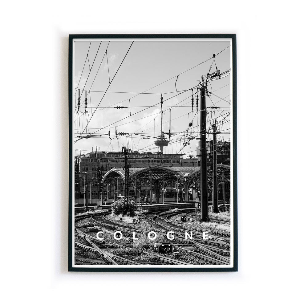 Schwarz Weiß Poster im Bilderahmen vom Kölner Hauptbahnhof, im Hintergrund der Fernsehturm. Unten im Bild steht in weiß Cologne - Central Station.