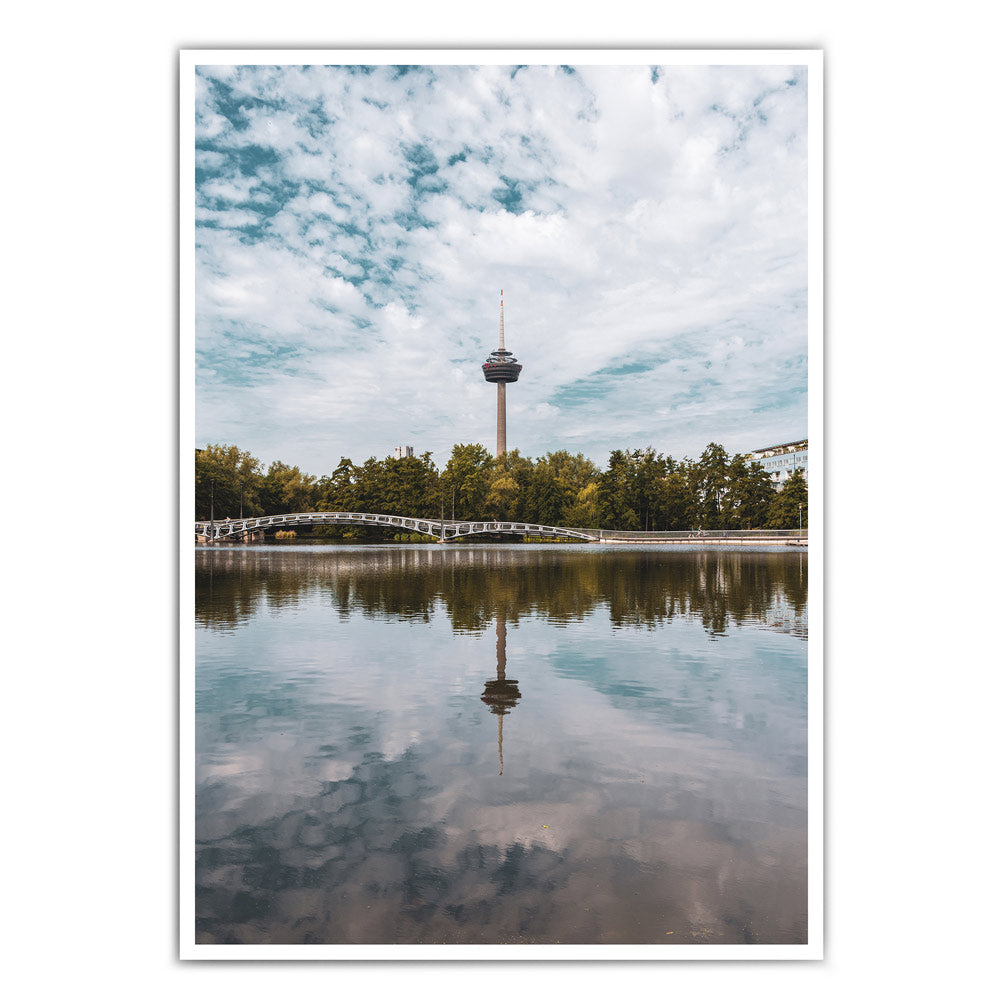 Sommer Köln Bild in Hochformat. Fernsehturm ist mittig im Bild und spiegelt sich im See im Vordergrund.