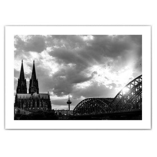 Schwarz Weiß Köln Poster im Querformat und weißen Rand. Sonnenuntergang bei wolkigen Himmel über dem Kölner Dom, Hohenzollernbrücke oder dem Fernsehturm.
