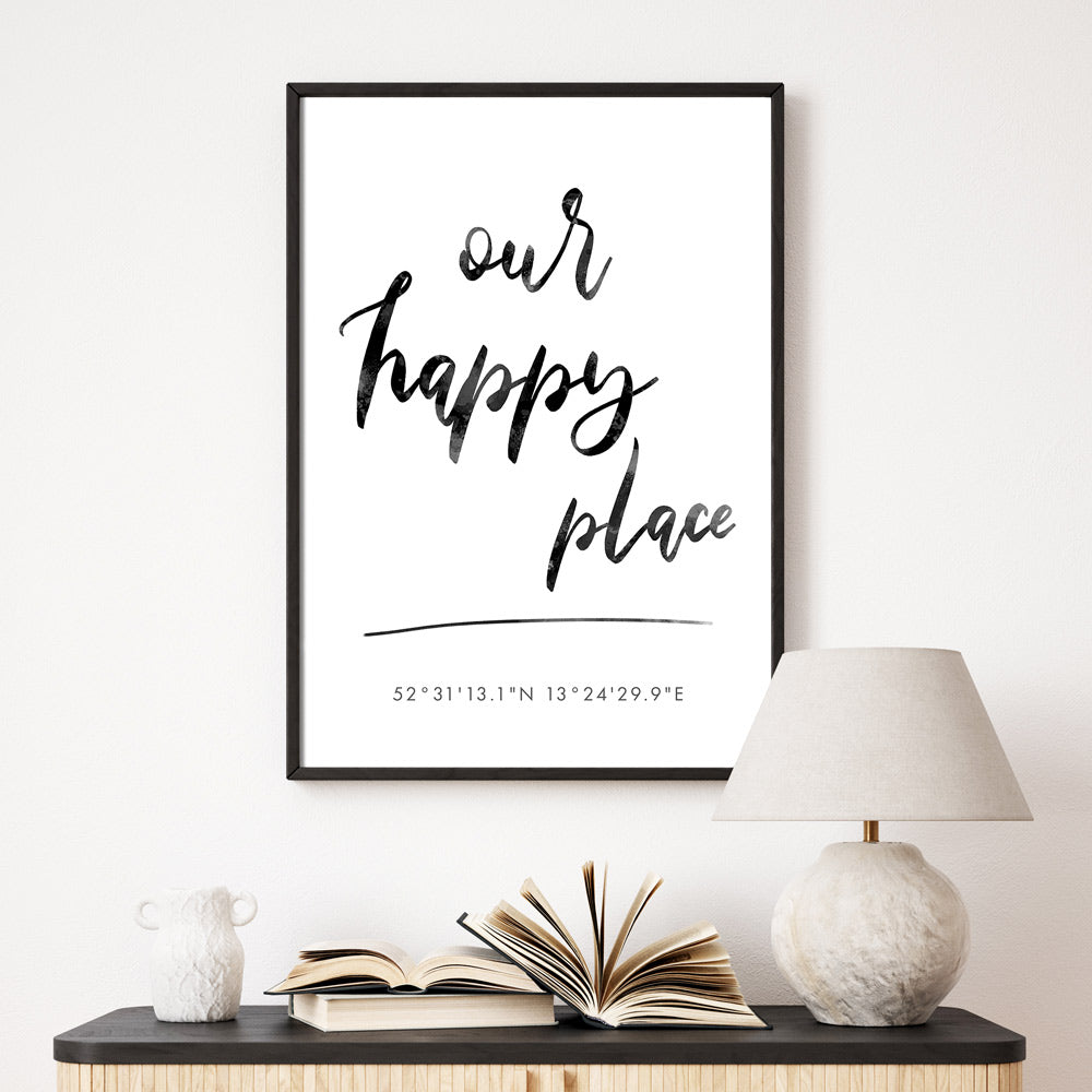 our happy place poster mit individuellen Koordinaten. Mit schwarzen Bilderrahmen an der Wand.