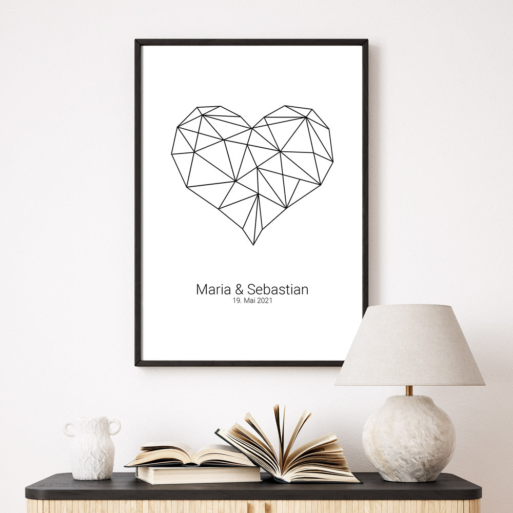 Herz Poster mit individuellen Namen und Datum darunter. Bild im schwarzen Bilderrahmen an der Wand.